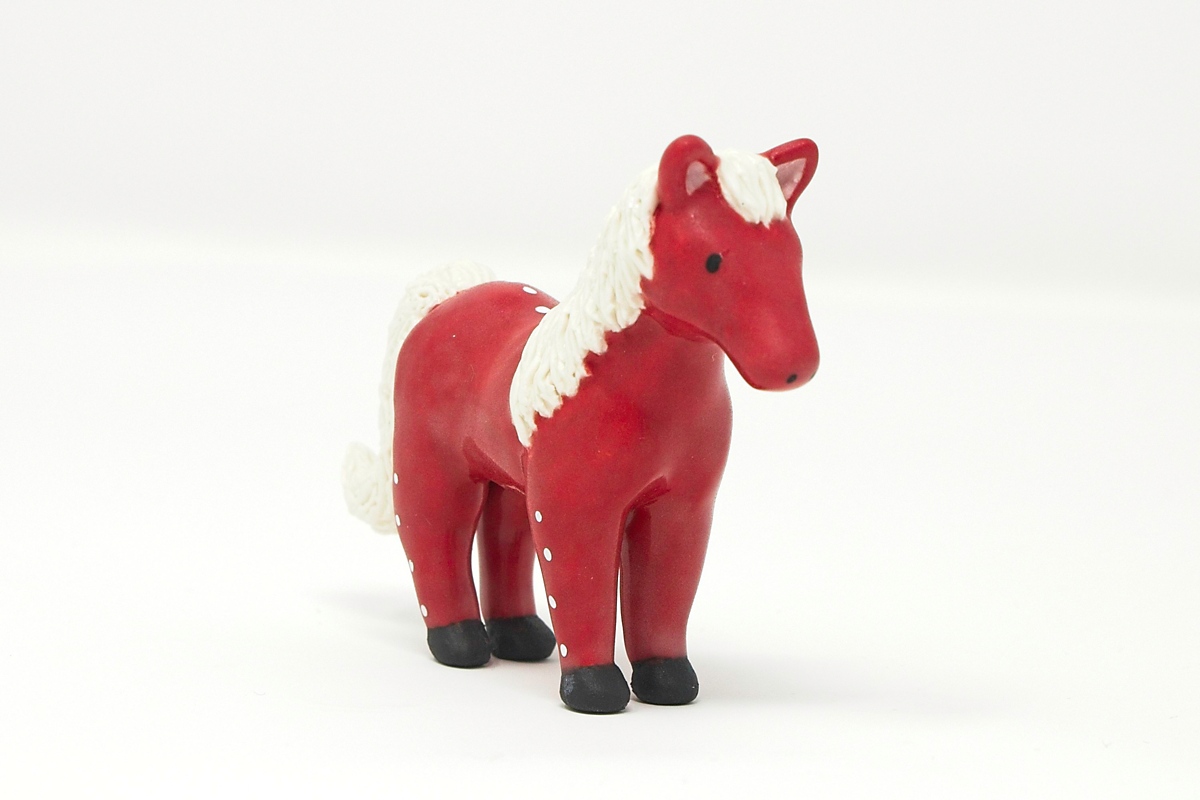 A miniature red ceramic horse.