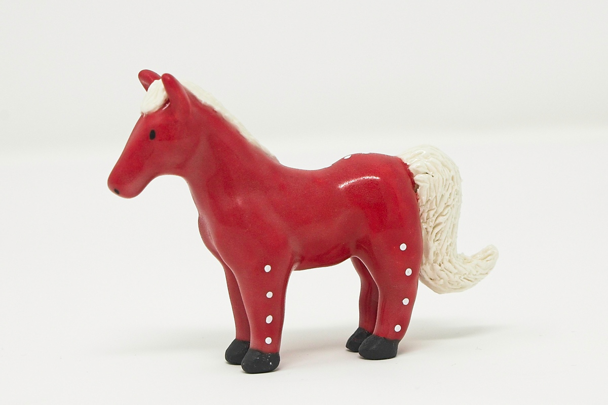 A miniature red ceramic horse.