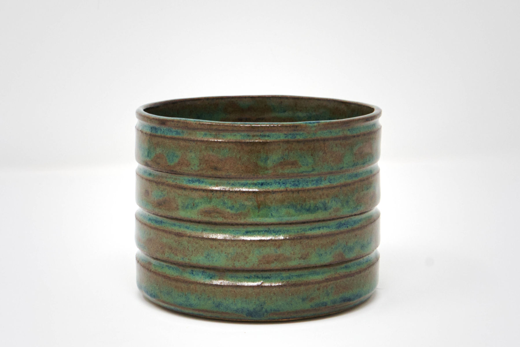 A blue-green handmade straight-sided vessel.